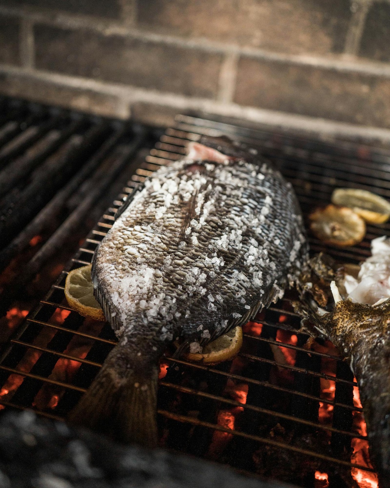 Loup entier sur la grille au charbon, gros sel et citron